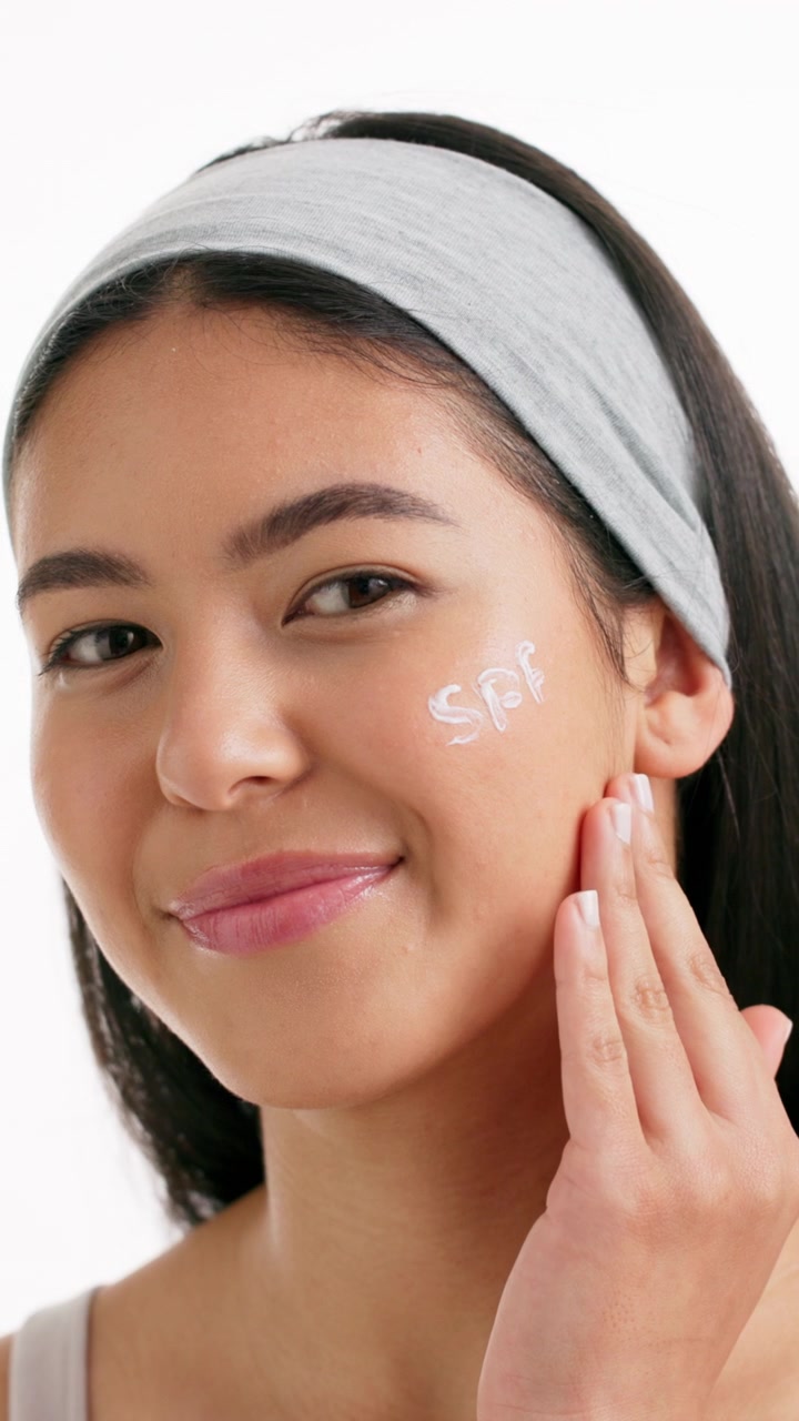 Young Woman Applying Sunscreen to Her Face