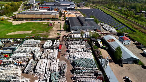 landfill waste site with trash compactors beside solar panels, aerial view from above