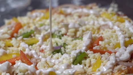 adding-mayo--mayonnaise--on-pizza-closeup-view