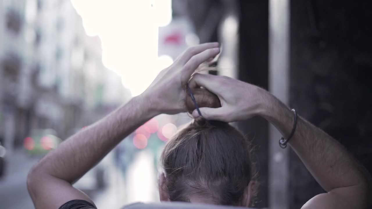 Man Adjusting Hair in City Street