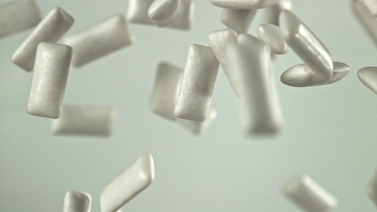 Palline di gomma da masticare bianche che cadono al rallentatore