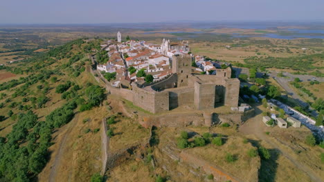 vista en órbita del castillo de mosaraz, pequeña ciudad en las murallas de la fortaleza, lago alqueva en el fondo, alentejo