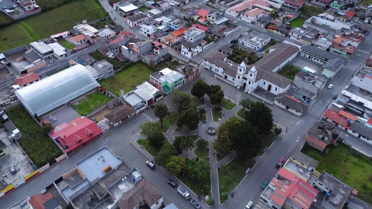 Drone che avanza verso il monumento e la chiesa della Mitad del Mundo sopra la piazza centrale di Calacali in Ecuador.