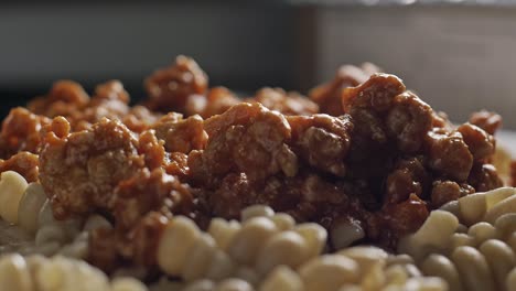 Parmesan-cheese-falling-on-plate-of-fusilli-pasta-with-meat-sauce,-close-up