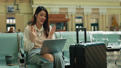 woman working on laptop at train station
