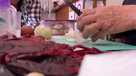 low angle of chef cutting onion in rural kitchen. close up