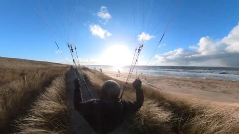 fpv shot of man speed soaring along top of dutch coastal dunes