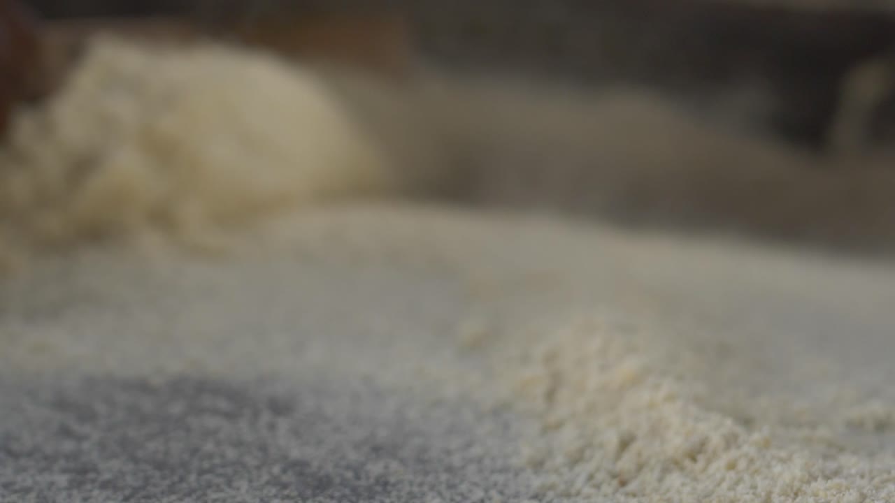 A CLOSE UP SHOT OF A WOMAN FRYING CASSAVA FLAKES IN NIGERIA, AFRICA.