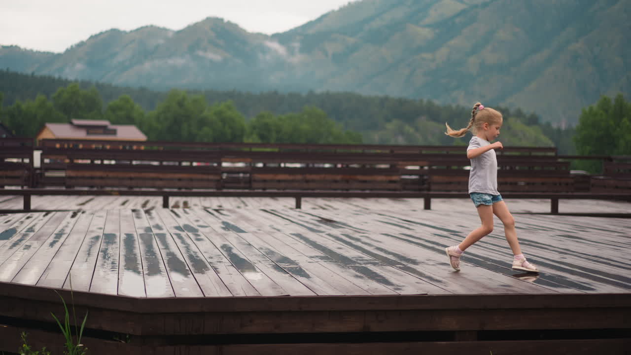 una niña bonita corre y salta en charcos con su hermano