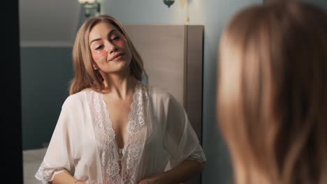 beautiful adult woman with patches under the eyes in lace standing in front of a mirror