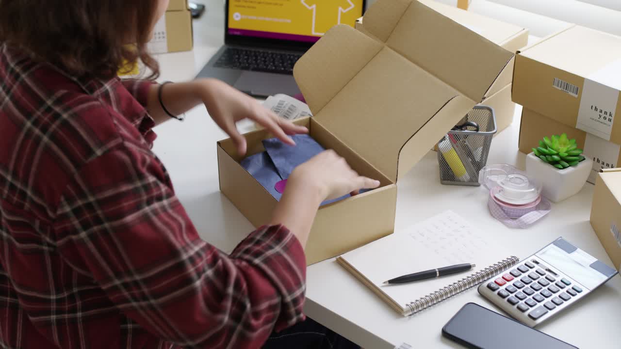 joven atractiva hermosa hipster asia mujer embalaje producto paquete de pequeña empresa orden tienda minorista en línea para la entrega al cliente. sme propietario trabajo preparando caja de dropshipping en la oficina en casa.