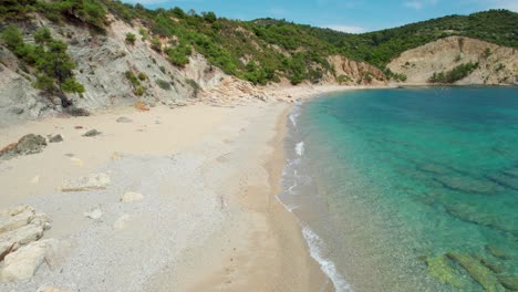 drone view, isolated and empty beach with white sand, turquoise water, lush vegetation and birds flying around, fari beach, thassos island, greece, europe