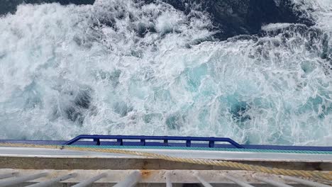 the view over the side of a passenger ferry as it sails through the ocean