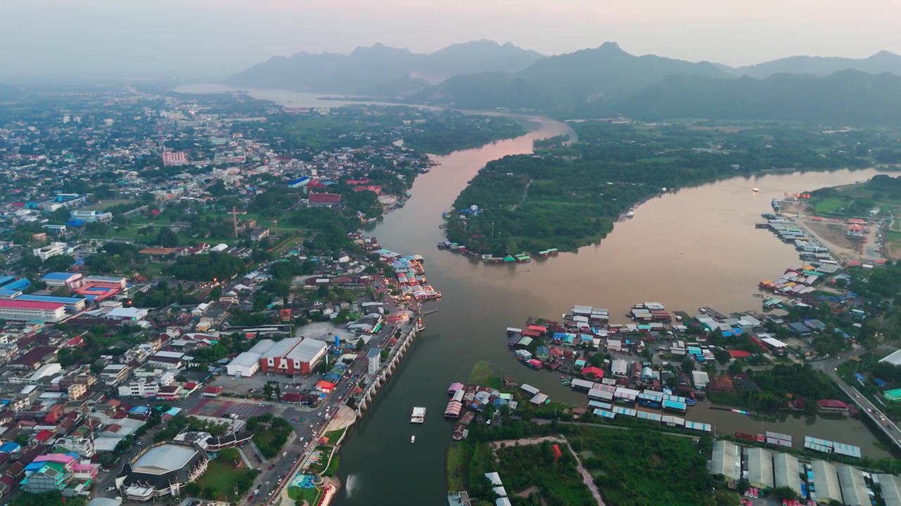 Vista aerea panoramica del paesaggio urbano di Kanchanaburi, case galleggianti sul fiume Kwai, riprese con drone sopra la Thailandia al tramonto, paesaggio montano.