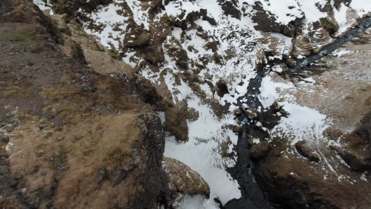 drone vuela sobre el agua helada del río y la roca nevada en islandia - drone