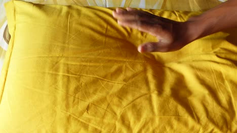 hand interacting with a yellow pillow