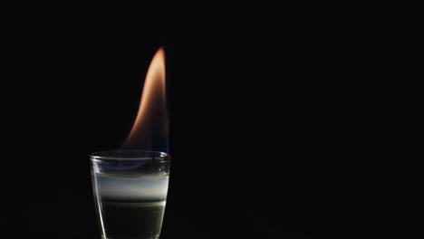 video de alcohol encendido con llama de fuego naranja y copia de espacio en fondo negro