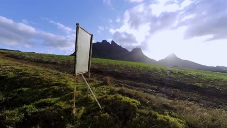 majestic mountain landscape with field and blank sign
