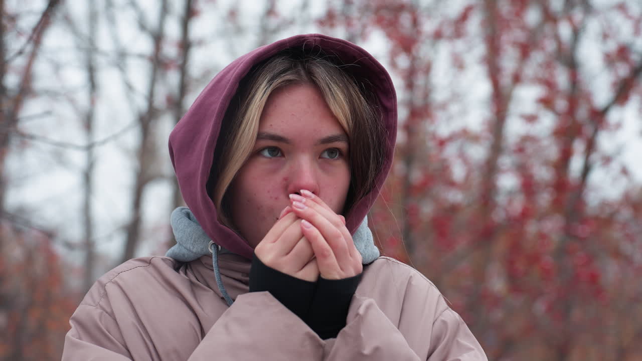 Teenager warming her hands in the winter