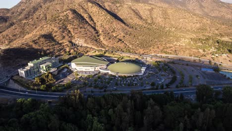 Cinematic-Aerial-Hyper-Lapse-Von-Monticello-Casino,-Umgeben-Von-Bäumen-Und-Bergen,-Kurz-Vor-Sonnenuntergang,-Rancagua,-Chile