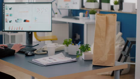 primer plano de una mujer empresaria sosteniendo un paquete de pedido de comida poniendo una bolsa de comida en la mesa