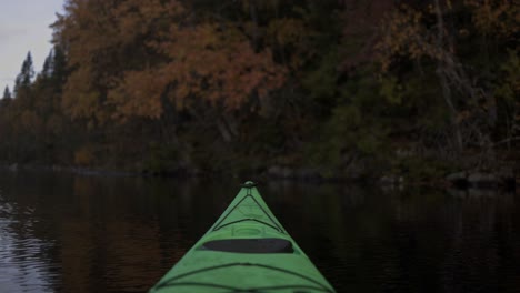 tip of green kayak floating in calm lake