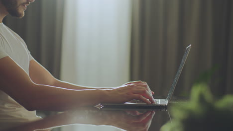 hombre trabajando en una computadora portátil en casa