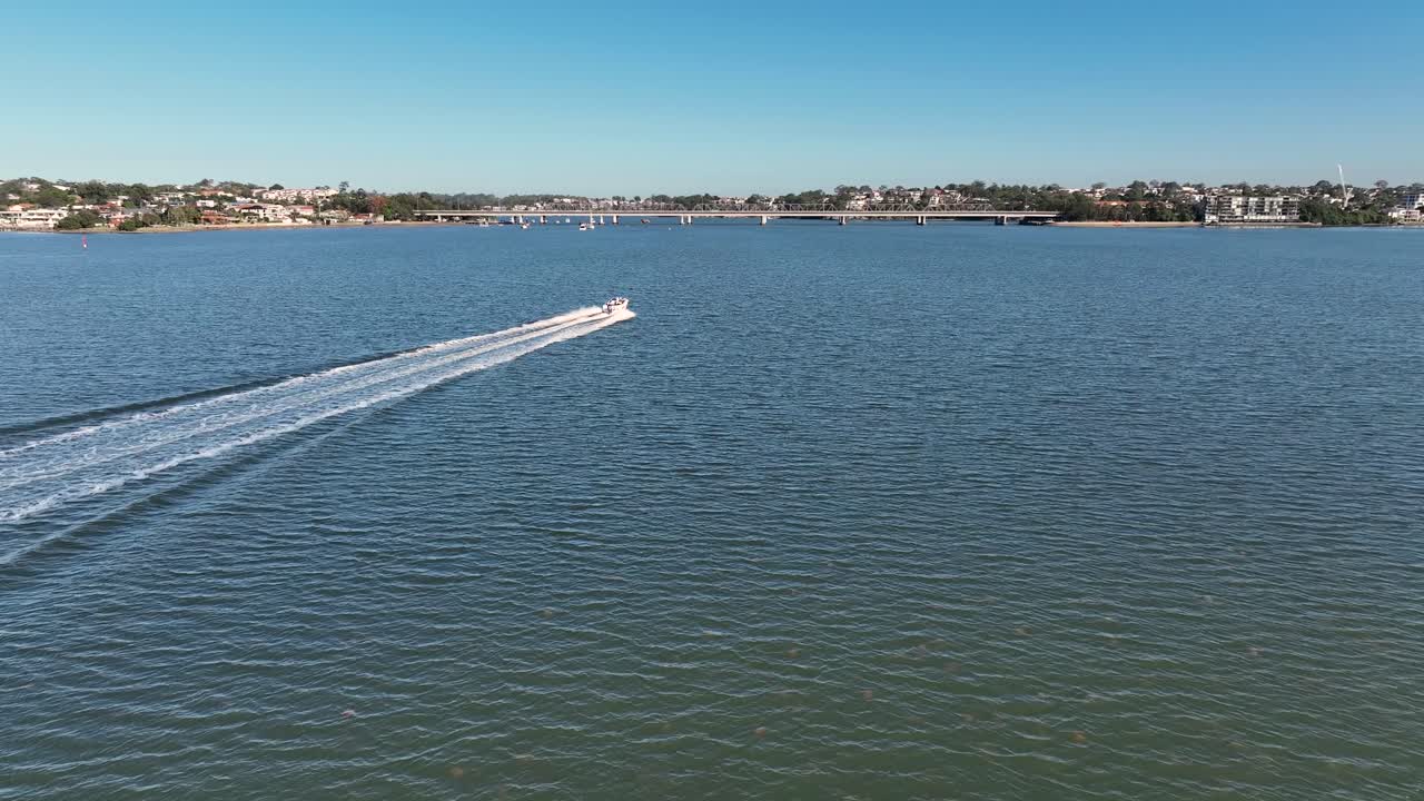 Drone che scende e segue una barca mentre risale rapidamente il fiume da Botany Bay, Sydney.