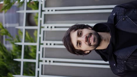 Hombre-Feliz-Sonriendo-En-La-Calle-Y-Sosteniendo-Una-Guitarra