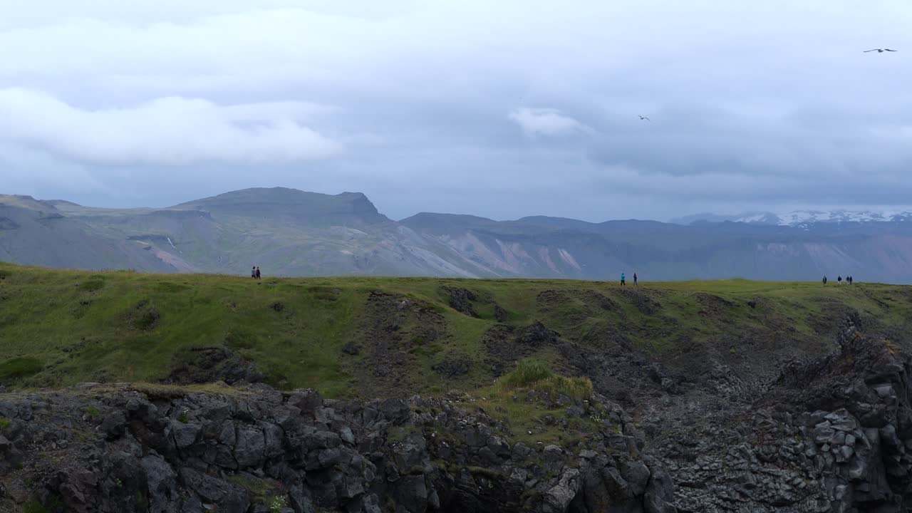 아이슬란드의 snæfellsnes 반도에 있는 arnarstapi에서 하이킹하는 사람들, 4k