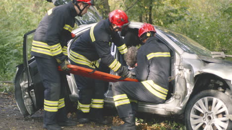 firefighters rescuing injured person from a car accident