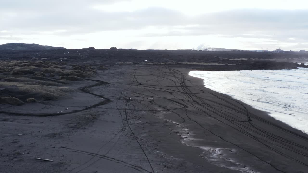 Extreme motor cross people on black volcanic beach, Sandvik cove, Iceland