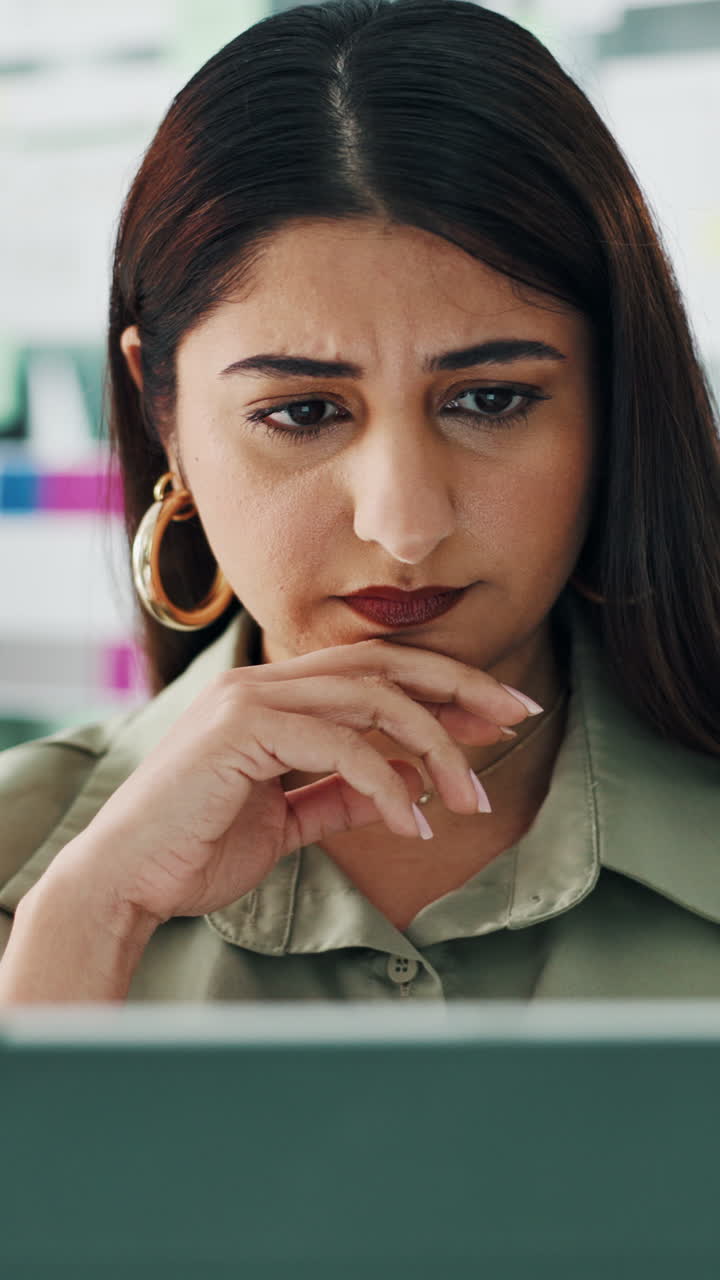 Serious Woman Concentrating on Laptop Screen in Office