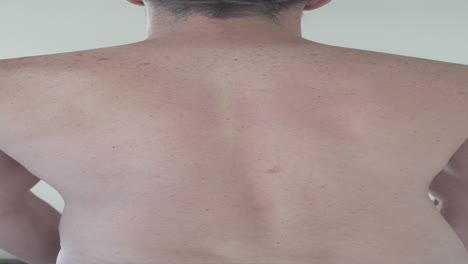 fotografía vertical de un atleta masculino posando y mostrando sus músculos de la espalda
