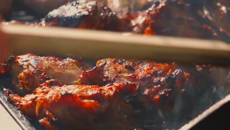 marinated chicken legs and thighs cooking on hot iron grills on bbq under bright sunlight with crispy delicious skin. summer concept street food picnic footage.