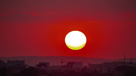 amanecer en un cielo rojo ardiente sobre una ciudad