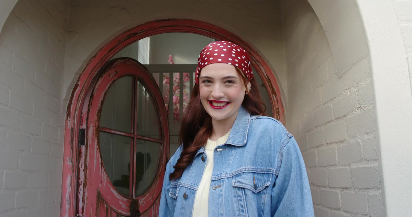 Mulher ouvindo uma deixa fora da câmera, virando, movendo-se, sorrindo e depois rindo para um retrato na varanda, com microfone