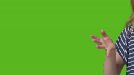 close up of young girl waving to camera against green screen