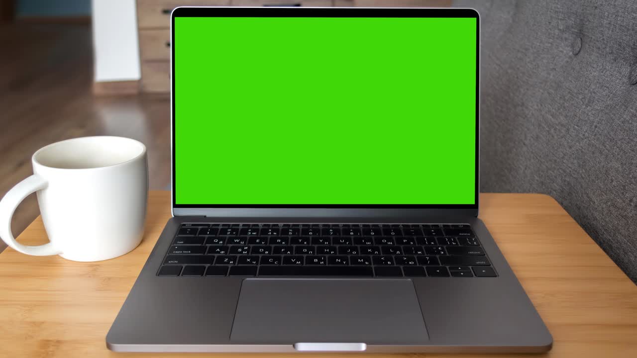 Green screen laptop computer sitting on a home work