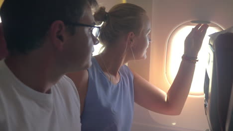 mujer y hombre mirando por la ventana del avión