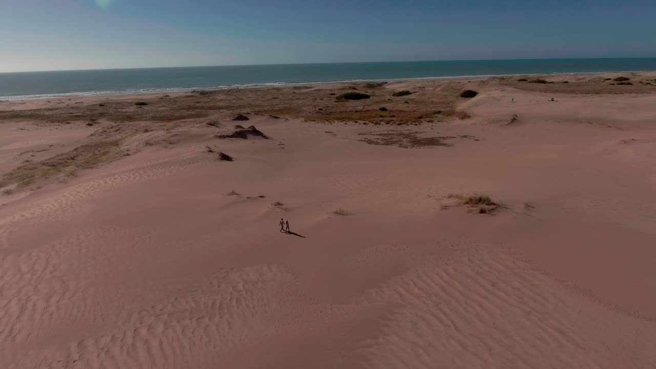 antena - dos personas en la playa, lago salado mar chiquita, córdoba, argentina, camión a la derecha