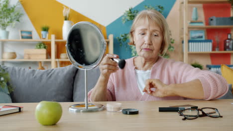 senior woman applying makeup