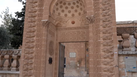 vemos la entrada principal del jardín hecha de piedra rosa de la mezquita latifiye de mardin