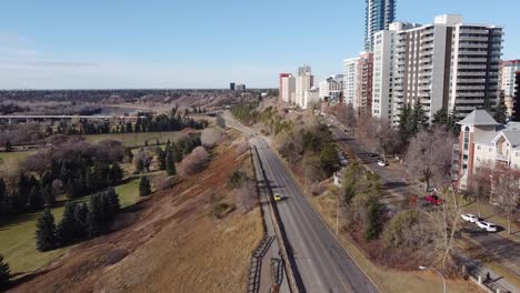 1-2-aerial-rise-fly-over-vip-park-adjacent-to-road-by-vip-rivers-ege-condominiums-apartments-high-rise-tower-on-a-blue-sky-sunny-fall-day-with-hardly-any-traffic-at-rush-hour-during-COVID-19-pandemic