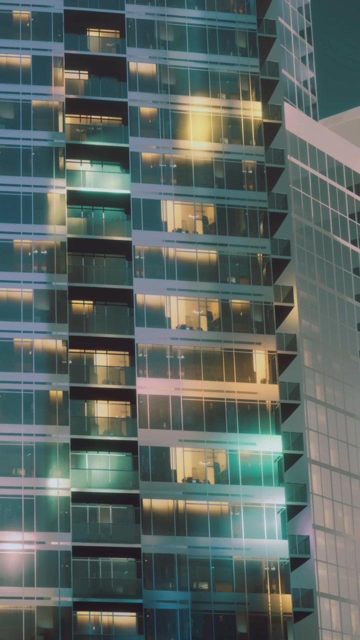 Edificios altos con luces brillantes vistos de noche en una ciudad