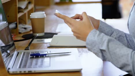 executive using mobile phone at desk in office 4k