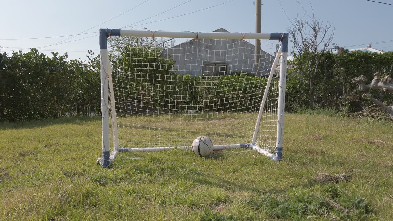 Soccer ball kicked and fly then roll into small goal net