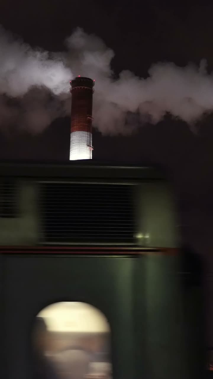 Smokestack at Night with Passing Train