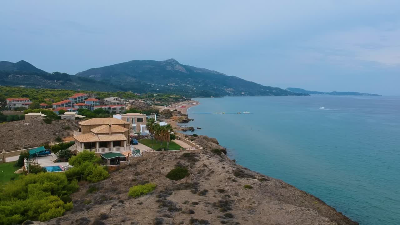 Point St. Nicholas cliffs on the island of Zakynthos Greece with beautiful beach homes, Aerial drone flyover shot looking northward