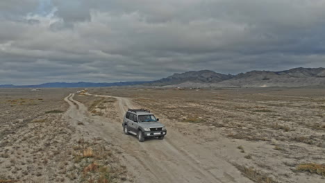 aerial over off road 4x4 car driving along gravel trail path